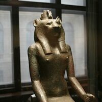 "Stone statue of Maahes, the God of War, featuring detailed lion head and warrior posture."