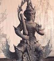 "Figurine of Thao Wessuwan, the Guardian of Wealth, with traditional ceremonial features."