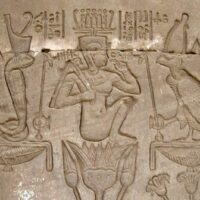 Wall carving of Ihy, the Egyptian god of music, depicted with a sistrum.