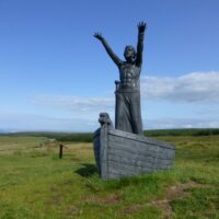 Stone statue of Manann&aacute;n Mac Lir with detailed sea-themed carvings.