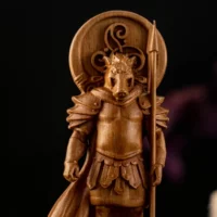 Wooden carving of Moccus, showing intricate details of his face.
