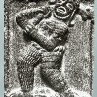 Carving of Ogma holding an object in his hand, symbolizing the gift of language.