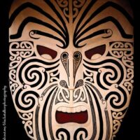 Decorative Ruaumoko mask featuring bold lines and symbolic facial expressions.
