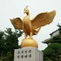 Golden statue of Samjoko perched on a shining golden sphere