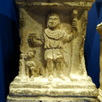 Ancient carving of Sucellus etched into stone, showing him holding a long-handled hammer.