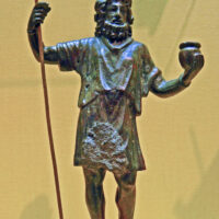 Statue of Sucellus holding a long-handled hammer and a pot of grain, representing abundance and the harvest.